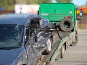 tow truck towing a smashed-up passenger car