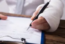 An injured individual filling out a health insurance claim showing that we know how to handle State Farm injury claims in Ohio