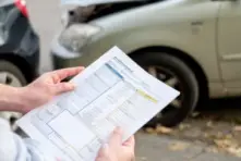 A man reading an accident statement form showing that we handle Geico insurance claims in Ohio