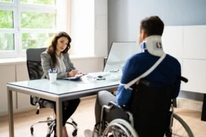 AN insuraance adajuster speakaing to a man in a wheel char with injuries showing that we handle Liberty Mutual insurance claims in Ohio