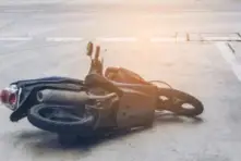 A motorcycle is lying on the road after an accident.