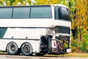 A damaged bus sits on the road after a crash.