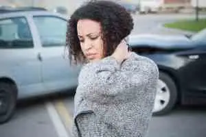 A woman holds her neck after a car accident in discomfort.
