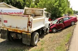 The aftermath of a head-on collision involving a passenger vehicle and a construction dump truck.