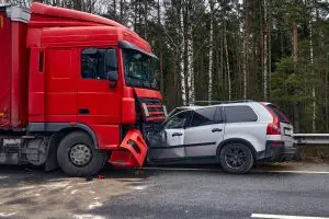 A large red truck crashes head-on into a passenger vehicle.
