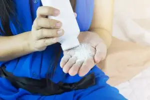 woman applying talcum powder to her body