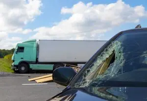 aftermath of semi-truck accident with shattered passenger vehicle windshield 