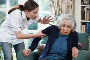 A nursing home attendant yells at their patient.