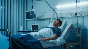 man lying in a hospital bed