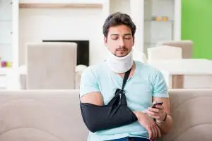 man with neck injury looks at phone