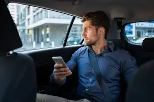 man in back seat of car with phone 