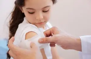 doctor bandaging a child’s shoulder