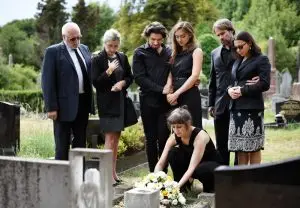 family laying flowers on a grave
