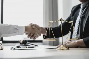 lawyer and client agreeing to work together by shaking hands