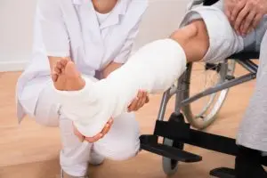 man in wheelchair in a leg cast