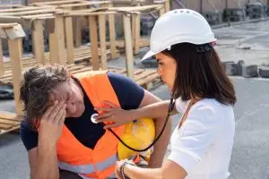 onsite clinician checking heartbeat of injured worker