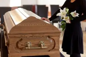 woman in mourning touching a coffin