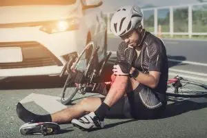 bicyclist holds knee in pain after accident