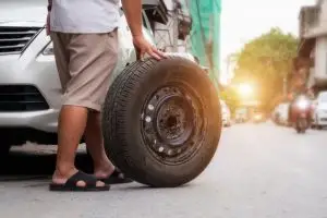 guy rolling out a tire
