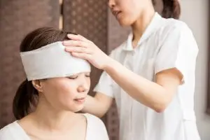 Asian woman getting head bandaged