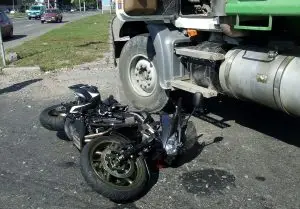 crashed motorcycle next to oil truck