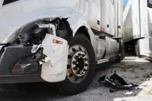 smashed fender of white tractor-trailer