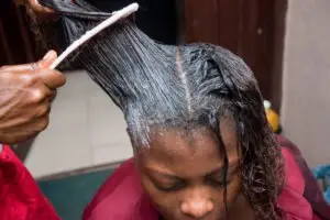 woman having a hair relaxer applied