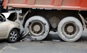 compact car in accident with dump truck