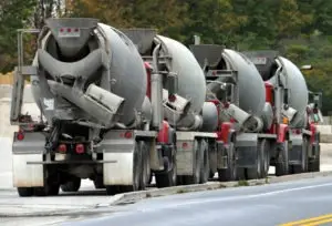 row-of-several-cement-trucks-on-the-side-of-the-road