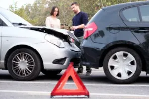 people examining damage after a car crash