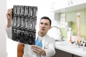 physician reviewing an MRI of vertebrae