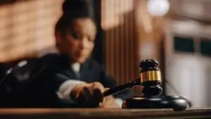 blurred image of a female African American judge striking a gavel.
