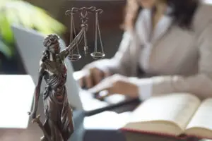 female lawyer working next to scales of justice