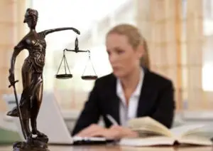 female lawyer working next to scales of justice