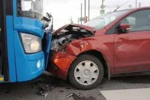 a head-on collision between a blue bus and a red car