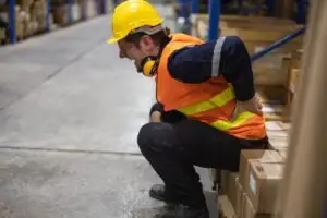 Worker holds shoulder in pain after workplace rotator cuff injury