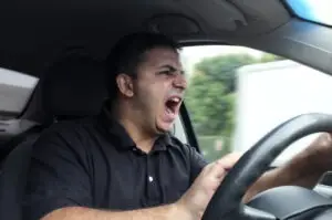 an angry man driving a vehicle