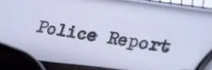 A typewriter states police report on paper.