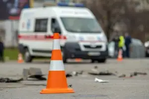 orange traffic cone and debris on the road after an ambulance accident