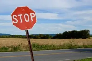 a leaning stop sign on a country road