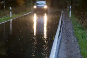 Car driving in bad weather on a Georgia road, at high risk for an auto accident. This may affect being able to file an auto accident claim. 