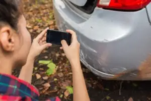 Car accident victim capturing the damages and injuries sustained in a car accident through photographs for a strong insurance claim.