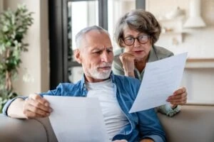 An elderly couple is reading a letter they received after they were in an accident.