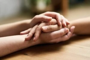 Holding hands offering comfort. How to report sexual abuse in Georgia