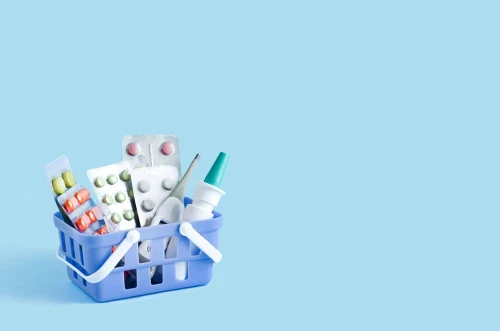 Purchase, delivery of medicines to your home. home first aid kit for colds, illnesses, viruses, epidemics. online purchase of medicines. drugs in basket on blue background, copy space