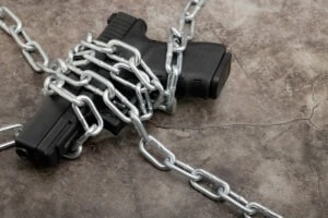 A gun wrapped in chains to represent someone’s lost gun rights, leaving people to ask, “How do I restore my gun rights in Ohio?”