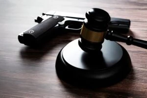 Gun lying on a table next to a gavel to represent the laws surrounding gun rights in Ohio.
