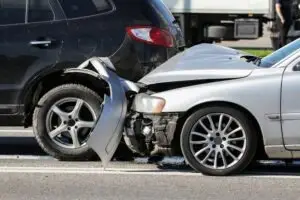 silver car crashes into dark SUV