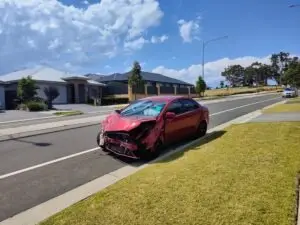 smashed red car after a hit-and-run