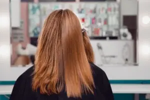 woman getting hair chemically straightened